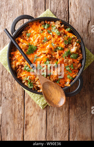 Deutsche Kohl Auflauf mit Hackfleisch, Tomaten, Zwiebeln und Cheddar Käse close-up in einer Pfanne auf dem Tisch. Vertikal oben Ansicht von oben Stockfoto