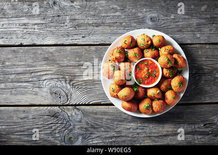 Wegerich Krapfen Klako auf einem weißen Teller mit heißer Soße, vegan Beilage, Street Food, afrikanische Küche, Ansicht von oben, flatlay, kopieren Raum Stockfoto