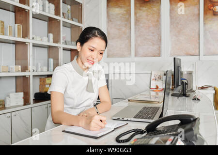 Junge lächelnde Salon an der Rezeption Stockfoto