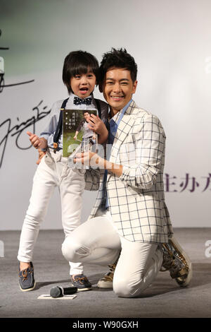 Taiwanesische Sänger und Schauspieler Jimmy Lin, rechts, und sein Sohn Kimi stellen während einer Pressekonferenz für Jimmys Autobiografie in Peking, China, 27. Juni 2014. Stockfoto