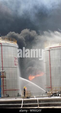 Chinesische Feuerwehrmänner Schlauch Wasser den Brand nach einer Explosion in einer Ölraffinerie von Sinopec Yangzi Petrochemical Company in Nanjing city löschen, Stockfoto