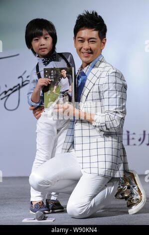 Taiwanesische Sänger und Schauspieler Jimmy Lin, rechts, und sein Sohn Kimi stellen während einer Pressekonferenz für Jimmys Autobiografie in Peking, China, 27. Juni 2014. Stockfoto