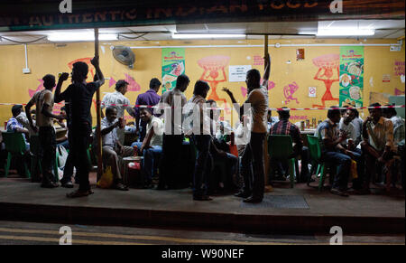 Wanderarbeiter in Little India an einem Sonntag Abend entspannen. Singapur Stockfoto