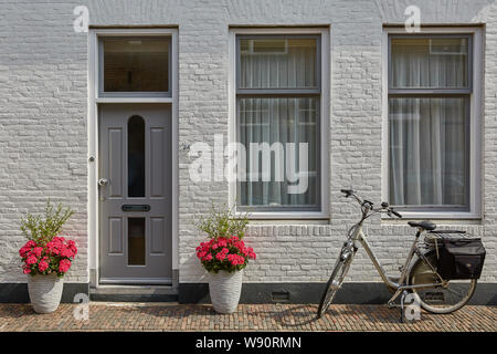 VLISSINGEN, Niederlande - 15. JUNI 2017: Hauseingang mit Blumen geschmückt. Rustikal-Konzept. Schönes Design Elemente der unbekannten Gebäude in Stockfoto