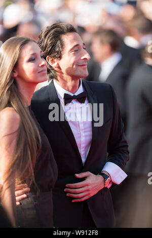 Amerikanischer Schauspieler Adrian Brody, rechts, und seine Freundin Lara Lieto posieren für Fotos, wie Sie an den roten Teppich für die Abschlussfeier der 67 t ankommen Stockfoto