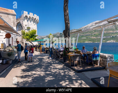 Touristen genießen Sie in einem Restaurant in der Nähe von Zakerjan Turm in der Altstadt von Korcula Stockfoto