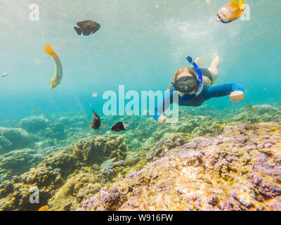 Glückliche Frau in Schnorcheln Maske Tauchen Unterwasser mit tropischen Fische im Korallenriff Meer Pool. Reisen, Wassersport Abenteuer im Freien, Schwimmen Stockfoto