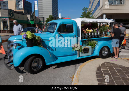 Schöne klassische Blume Gypsy blaue Blumen" Fahrzeug ist mit frischen Blumen in Fort Wayne's Bauernmarkt in der Innenstadt von Fort Wayne, Indiana, USA geladen. Stockfoto