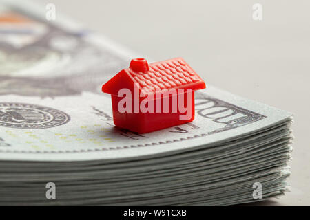 Rotes Haus auf einem Stapel Geld. Das Konzept von Steuern oder Immobilien Darlehen. Stockfoto