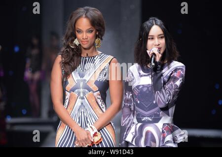 Amerikanische supermodel, Schauspielerin und TV-Produzent Tyra Banks, Links, wirft mit chinesischen Sänger Shang Wenjie auf dem Laufsteg bei einer Modenschau der Chinesischen real Stockfoto