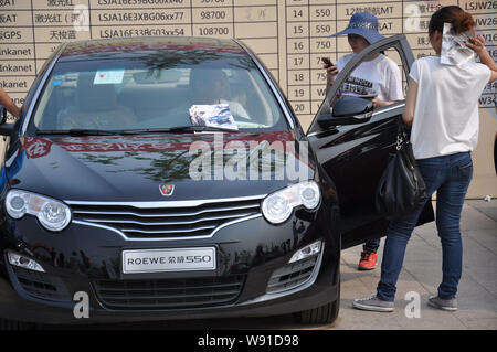 ---- Besucher Blick an einem Roewe 550 der SAIC Motor während eines Auto Show in Qingdao Stadt, East China Provinz Shandong, 5. Mai 2012. SAIC Motor Corp., Stockfoto