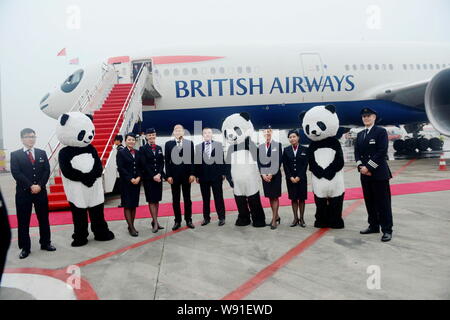 ---- Flugbegleiter der Flug BA 89 von London nach Chengdu von British Airways posieren vor dem Flugzeug lackiert wie eine lächelnde Riese suchen Stockfoto
