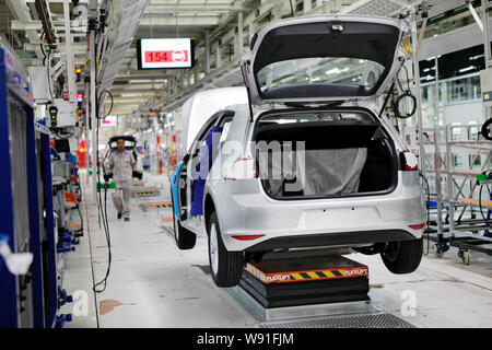 Ein chinesischer Arbeiter ist auf einem Fließband im neuen Werk von FAW-Volkswagen in Foshan, China Guangdong Provinz, 25. September 2013 gesehen. Volks Stockfoto