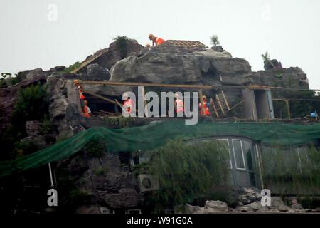 Chinesische Arbeiter tear down the Rock Garden an der Bergspitze Villa, die von Professor Zhang Beiqing auf dem Dach seines Wohnhauses eingebaut ist Stockfoto