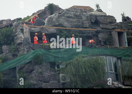 Chinesische Arbeiter tear down the Rock Garden an der Bergspitze Villa, die von Professor Zhang Beiqing auf dem Dach seines Wohnhauses eingebaut ist Stockfoto