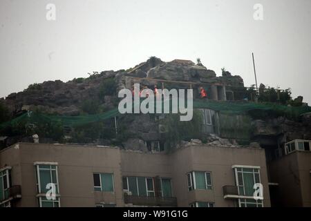 Chinesische Arbeiter tear down the Rock Garden an der Bergspitze Villa, die von Professor Zhang Beiqing auf dem Dach seines Wohnhauses eingebaut ist Stockfoto