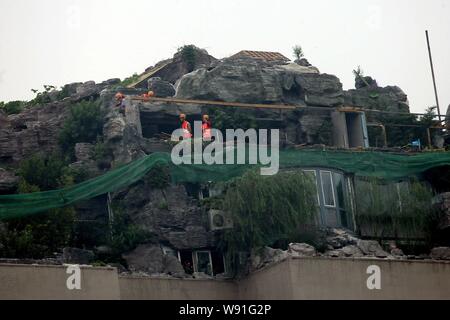 Chinesische Arbeiter tear down the Rock Garden an der Bergspitze Villa, die von Professor Zhang Beiqing auf dem Dach seines Wohnhauses eingebaut ist Stockfoto