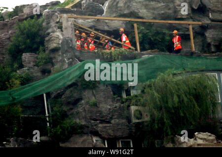 Chinesische Arbeiter tear down the Rock Garden an der Bergspitze Villa, die von Professor Zhang Beiqing auf dem Dach seines Wohnhauses eingebaut ist Stockfoto