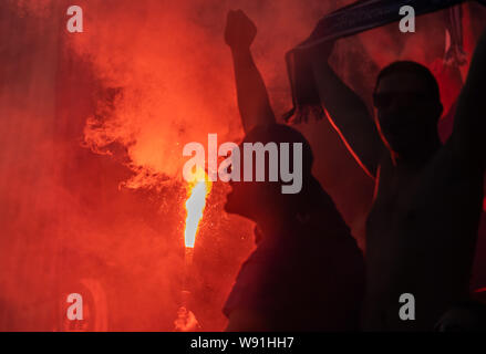 Chemnitz, Deutschland. 11 Aug, 2019. Fussball: DFB-Pokal, Chemnitzer FC - Hamburger SV, Runde 1, im Stadion auf der Gellertstraße. Die Hamburger fans Pyrotechnik entzünden. Credit: Robert Michael/dpa-Zentralbild/dpa - WICHTIGER HINWEIS: In Übereinstimmung mit den Anforderungen der DFL Deutsche Fußball Liga oder der DFB Deutscher Fußball-Bund ist es untersagt, zu verwenden oder verwendet Fotos im Stadion und/oder das Spiel in Form von Bildern und/oder Videos - wie Foto Sequenzen getroffen haben./dpa/Alamy leben Nachrichten Stockfoto
