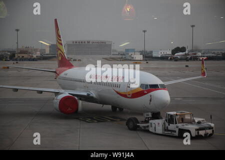 --FILE - eine Boeing 737-800 Düsenflugzeug von Hainan Airlines wird der Parkplatz Schürze an der Beijing Capital International Flughafen in Peking, Chi abgeschleppt Stockfoto