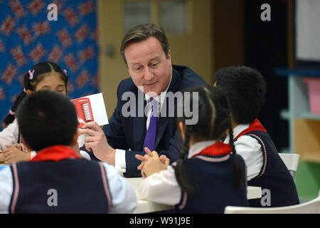 Der britische Premierminister David Cameron, Zentrum, hält eine Karte mit einem Bild von einer Telefonzelle wie er spricht mit jungen chinesischen Studenten bei seinem Besuch Stockfoto