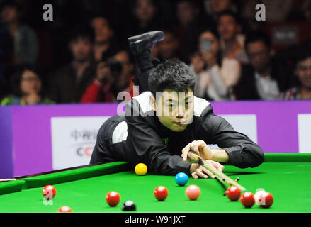 Liang Wenbo von China spielt einen Schuß gegen Ronnie OSullivan von England in der zweiten Runde des 2013 World Snooker Internationale Meisterschaft Stockfoto