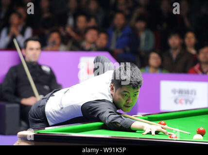 Liang Wenbo von China spielt einen Schuß gegen Ronnie OSullivan von England in der zweiten Runde des 2013 World Snooker Internationale Meisterschaft Stockfoto