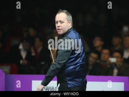 John Higgins von Schottland klebt er seine Zunge heraus, als er einen Schuß gegen Joe Swail in Nordirland in der ersten Runde der 2013 Wor Stockfoto