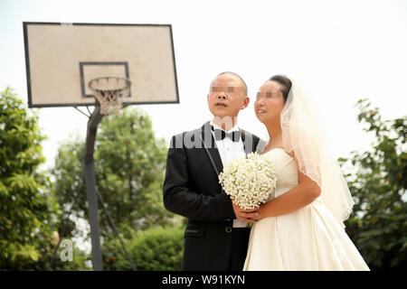 Chinesische Insasse Zhang Cheng, Links, wirft mit seiner Frau Yang Yumei während einer Hochzeit Fotografie Event auf yongchuan Gefängnis in Chongqing, China, 10. August Stockfoto