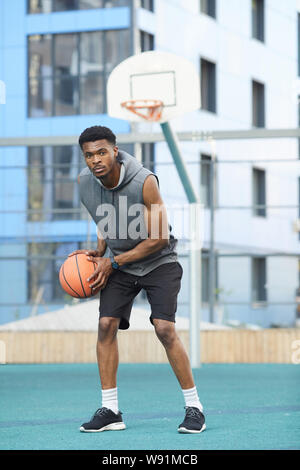 In voller Länge Porträt der Afrikanischen Basketball Spieler üben im Freien Gericht Stockfoto