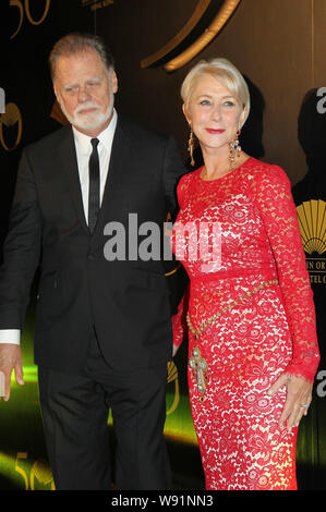 Englische Schauspielerin Helen Mirren, rechts, und ihr Ehemann Taylor Hackford darstellen, da Sie an einem Cocktail Party kommen zum 50-jährigen Jubiläum des Mand zu feiern. Stockfoto