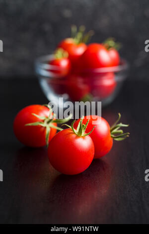 Die roten Tomaten auf Schwarz. Stockfoto