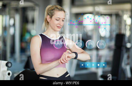 Frau mit smart Watch als Fitness Tracker beim Trainieren im Fitnesscenter Stockfoto