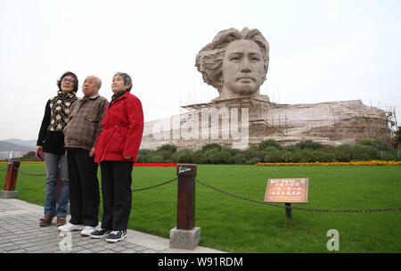 ---- Besucher posieren für Fotos vor dem riesigen Stein Statue schildert der ehemalige chinesische Führer Mao Zedong in seinem 30s in Changsha City, Central C Stockfoto