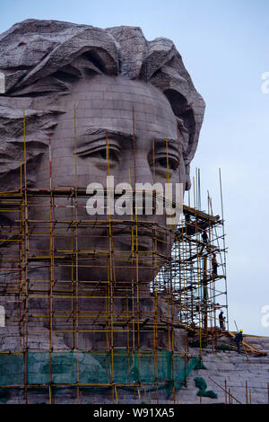 ------ Chinesische Arbeiter bauen Gerüste, die riesige Statue schildert der ehemalige chinesische Führer Mao Zedong in seinem 30s in Changsha City zu reinigen, Centr Stockfoto