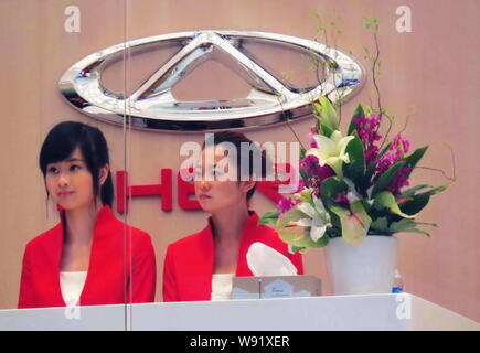 ------ Chinesische Mitarbeiter sind auf dem Stand von Chery während des 15 Shanghai Internationalen Automobil- Ausstellung, bekannt als Auto Shanghai gesehen Stockfoto