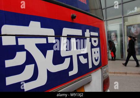 ---- Ein Fußgänger geht hinter einem Schild der Französischen Supermarktkette Carrefour in Peking, China, 28. März 2013. Ein Messer schwingenden Mann verletzt Stockfoto