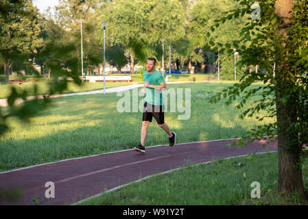 Hübscher junger Sportler Joggen in der Natur Stockfoto