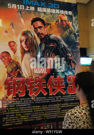 Eine chinesische Frau sieht ein Poster zum Film Iron Man 3 an einem Kino in Kunshan City, Central China Provinz Hubei, 1. Mai 2013. Iron Man 3 hat reasser Stockfoto
