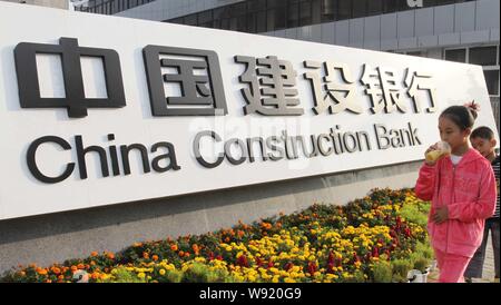 ---- Ein Fußgänger geht Vergangenheit ein Zeichen der China Construction Bank, als CCB in Xuchang Stadt bekannt, Zentrale China Provinz Henan, 30 September 201 Stockfoto