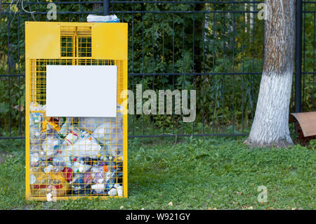 Gelb Eisen Gitter für Kunststoff Abfällen zur Verwertung in der Nähe der grünen Bäume im Park Stockfoto