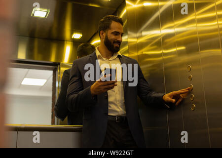 Positiv erfreut, bärtiger Mann auf die Schaltfläche Suchen Stockfoto