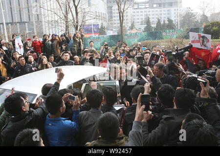 Englische Fußball-Superstar David Beckham, Mitte, durch eine Masse von Fans umgeben ist, wie er an der Shangri-la Hotel in Qingdao Stadt ankommt, Ostchina Shando Stockfoto