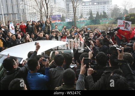 Englische Fußball-Superstar David Beckham, Mitte, durch eine Masse von Fans umgeben ist, wie er an der Shangri-la Hotel in Qingdao Stadt ankommt, Ostchina Shando Stockfoto