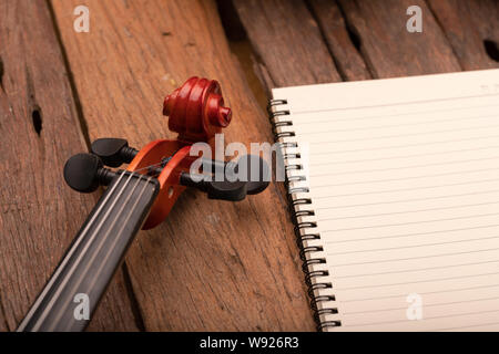 Nahaufnahme Violine Orchester Instrumental- und Notebook über Holz- Hintergrund wählen Sie Fokus flache Tiefenschärfe Stockfoto