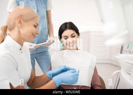 Fröhliche Frau auf Zähne, die Proben. Stockfoto