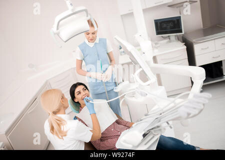 Frau erhalten ihren zahnmedizinischen Behandlung vor Weiß werden. Stockfoto