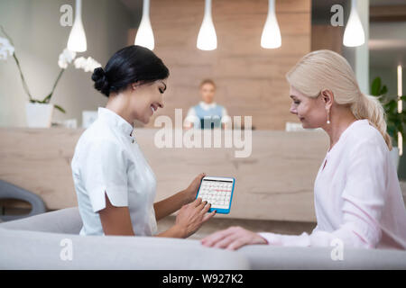 Frau zur Festsetzung einer Sitzung mit Ihrem Zahnarzt. Stockfoto