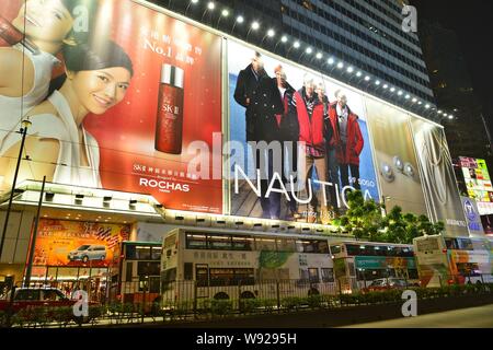 ---- Doppeldecker Busse und Taxis vorbei an Plakaten an der Sogo Department Store in Causeway Bay, Hong Kong, China, 8. Dezember 2012. Hong Kongs Stockfoto