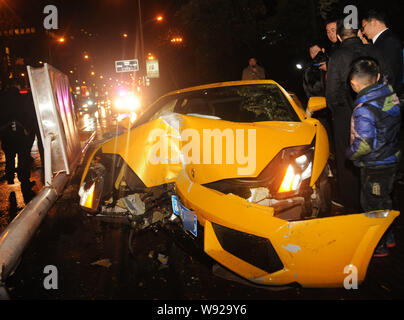 ------ Zuschauer Blick auf eine beschädigte Lamborghini Sportwagen, nachdem es in einem telegraphenmast auf einer Straße in Jinhua City abgestürzt, East China Zhejiang prov Stockfoto